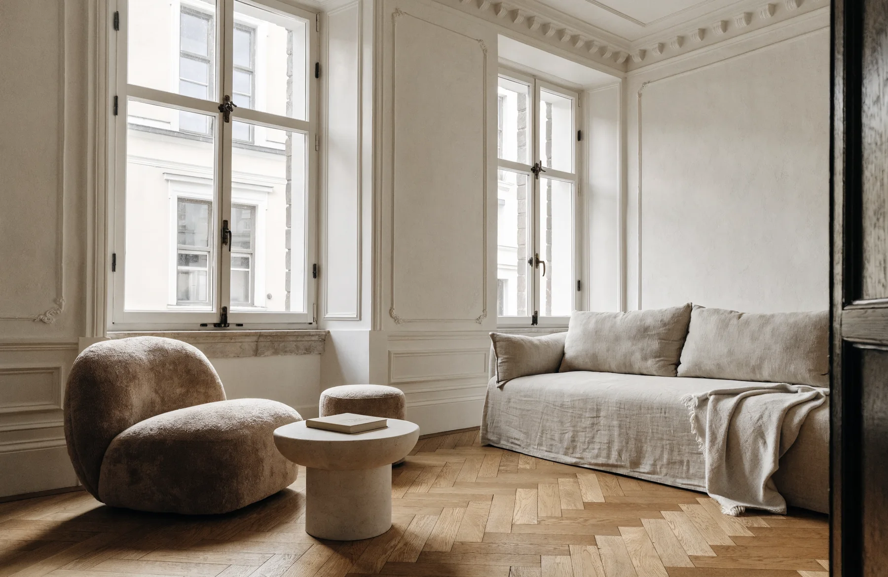 Helles Altbau-Wohnzimmer mit Fischgrätparkett und großen Fenstern